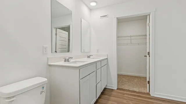 a bathroom with a sink a toilet and a mirror