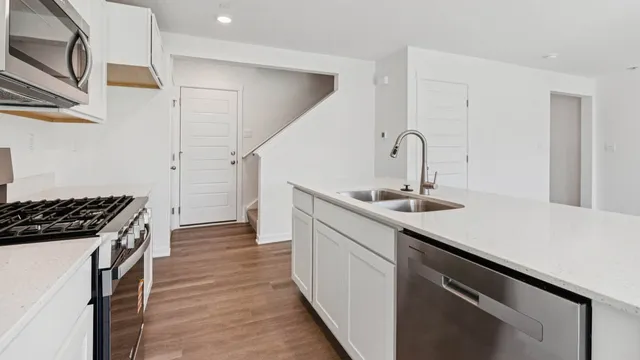 a kitchen with a sink and stainless steel appliances