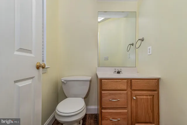 a bathroom with a granite countertop toilet a sink and a mirror