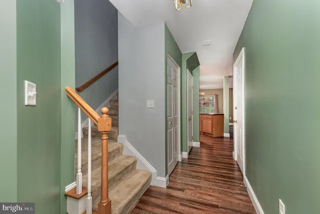 a view of a hallway with wooden floor and staircase