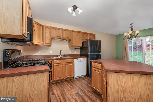 a kitchen with stainless steel appliances granite countertop a stove refrigerator sink and cabinets