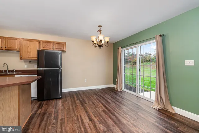 a view of a kitchen with wooden floor and an empty space