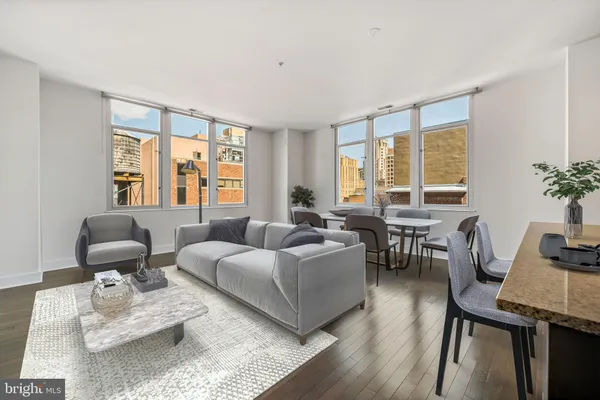 a living room with furniture and floor to ceiling windows