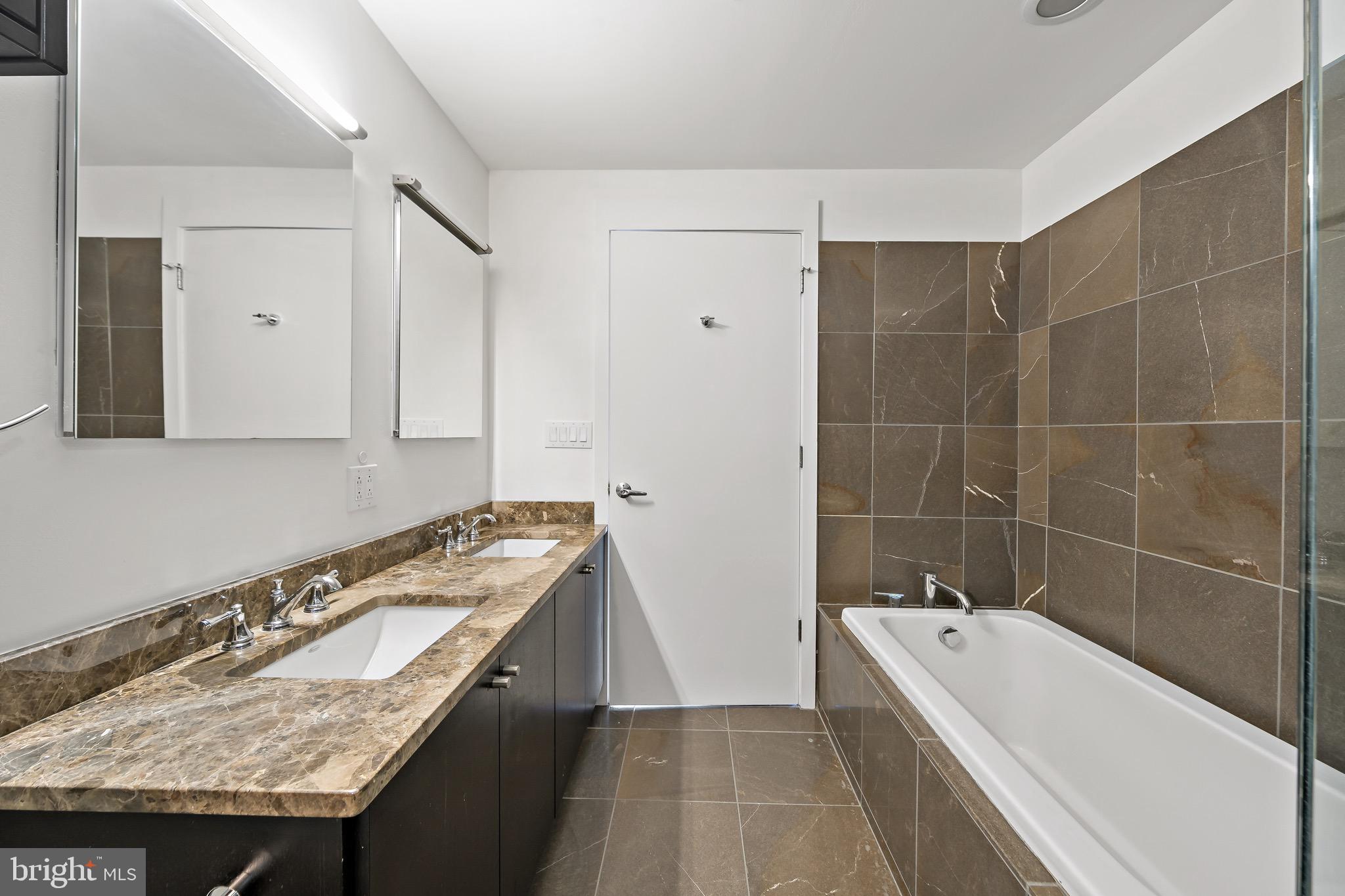 1101 Locust Street, Unit 7I Philadelphia, PA 19107 - Photo 15 of 27 a bathroom with a granite countertop tub and a sink