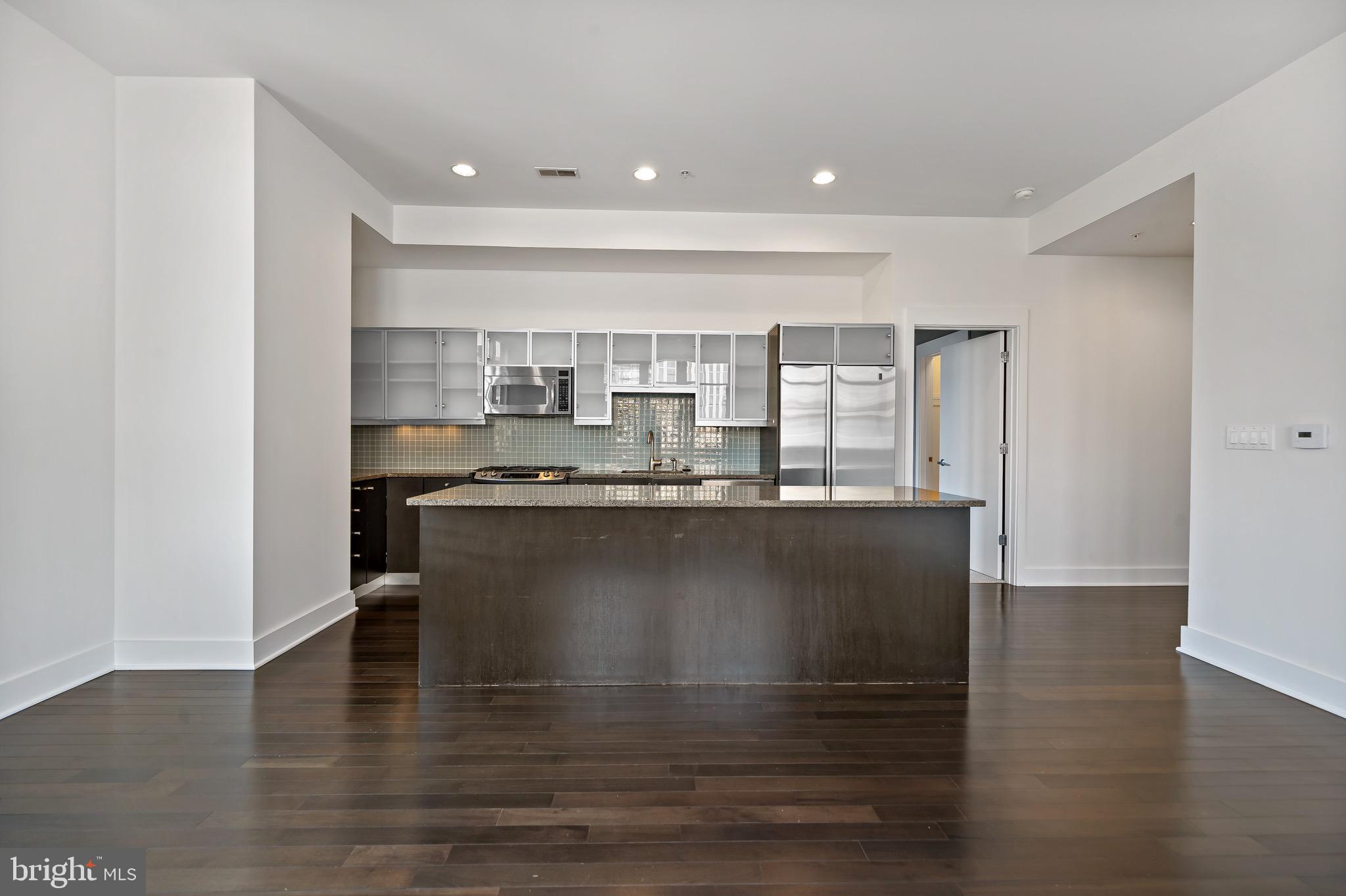 1101 Locust Street, Unit 7I Philadelphia, PA 19107 - Photo 6 of 27 a large kitchen with granite countertop a stove a sink and a refrigerator