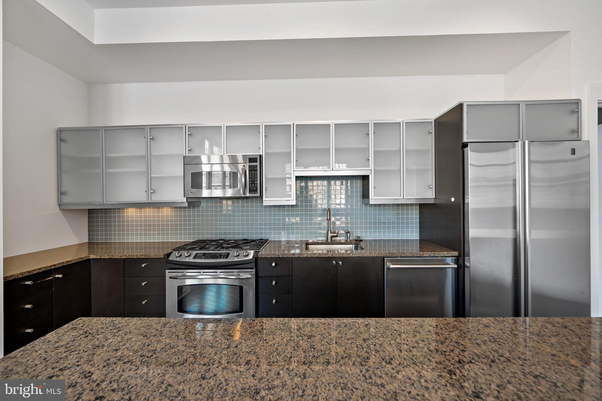 1101 Locust Street, Unit 7I Philadelphia, PA 19107 - Photo 7 of 27 a kitchen with stainless steel appliances granite countertop a sink stove and refrigerator