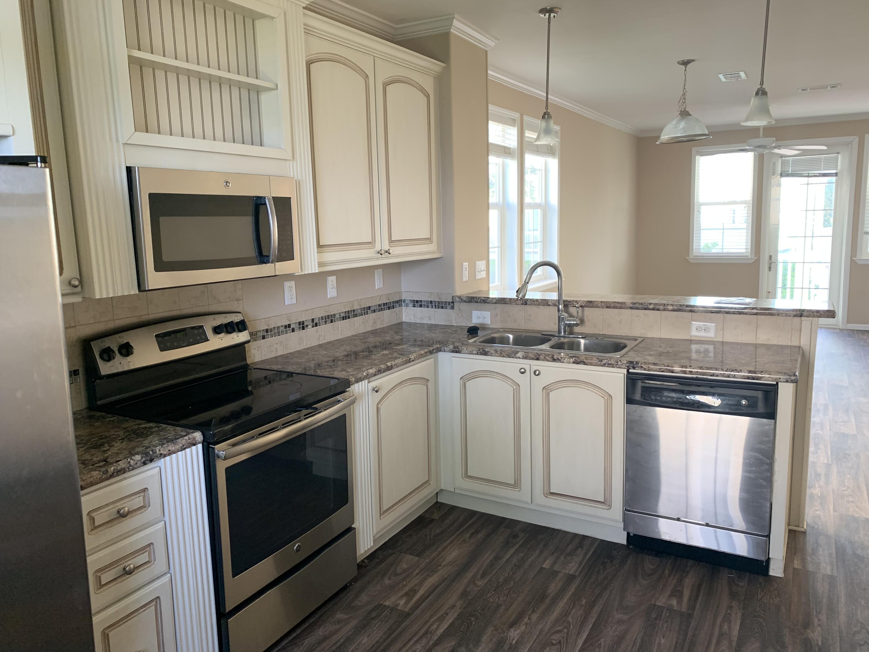 a kitchen with stainless steel appliances granite countertop a stove a sink and a microwave
