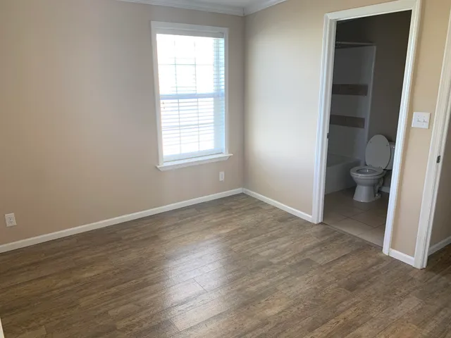 an empty room and a bathroom with toilet