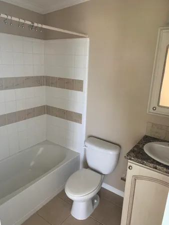 a white toilet sitting next to a bath tub