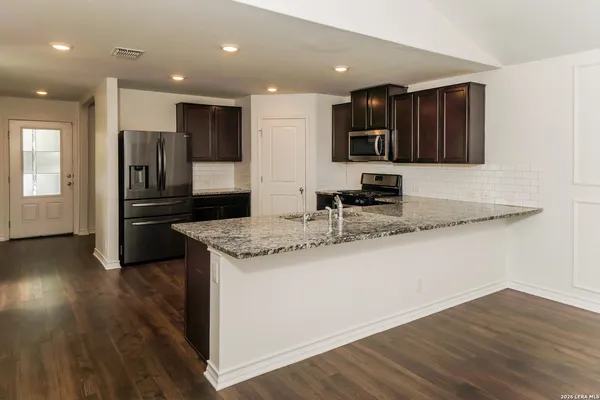 a kitchen with stainless steel appliances granite countertop a refrigerator and a stove top oven