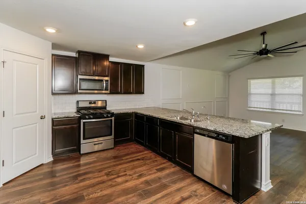 a kitchen with stainless steel appliances granite countertop a stove a sink and a refrigerator