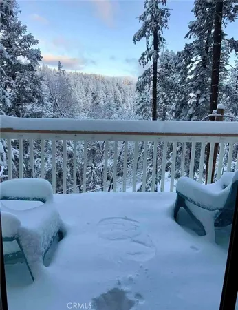 a view of roof deck with couches and wooden fence