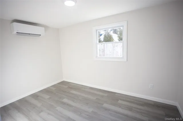 an empty room with wooden floor and window