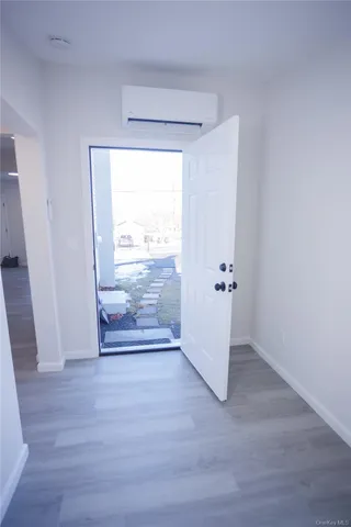 an empty room with wooden floor and a ceiling fan