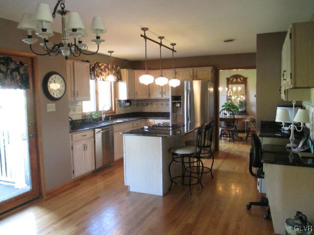 343 Forest Road Nazareth, PA 18064 - Photo 7 of 32 a kitchen with stainless steel appliances granite countertop a stove and cabinets with wooden floor