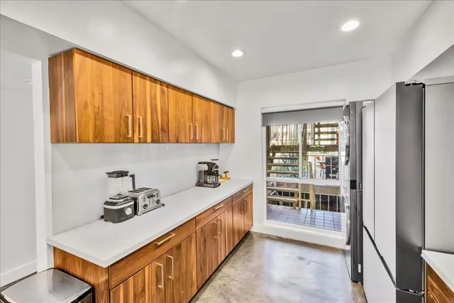 a kitchen with stainless steel appliances granite countertop a stove a sink and a refrigerator with wooden floor