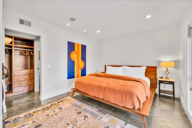 a bedroom with a bed and a painting on the wall