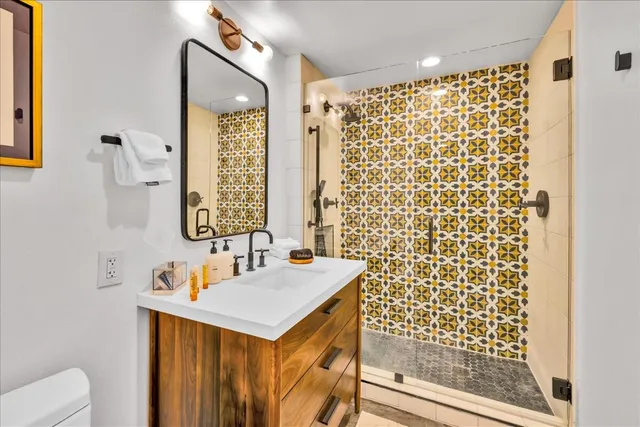 a bathroom with a sink a toilet and shower