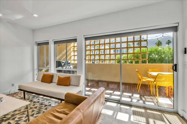 a living room with furniture and a floor to ceiling window