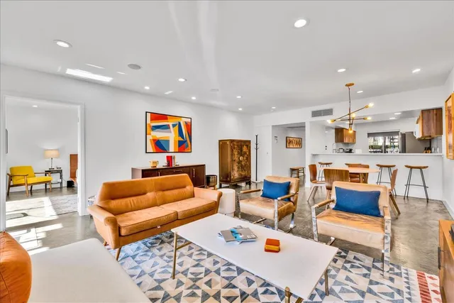 a living room with furniture and kitchen view