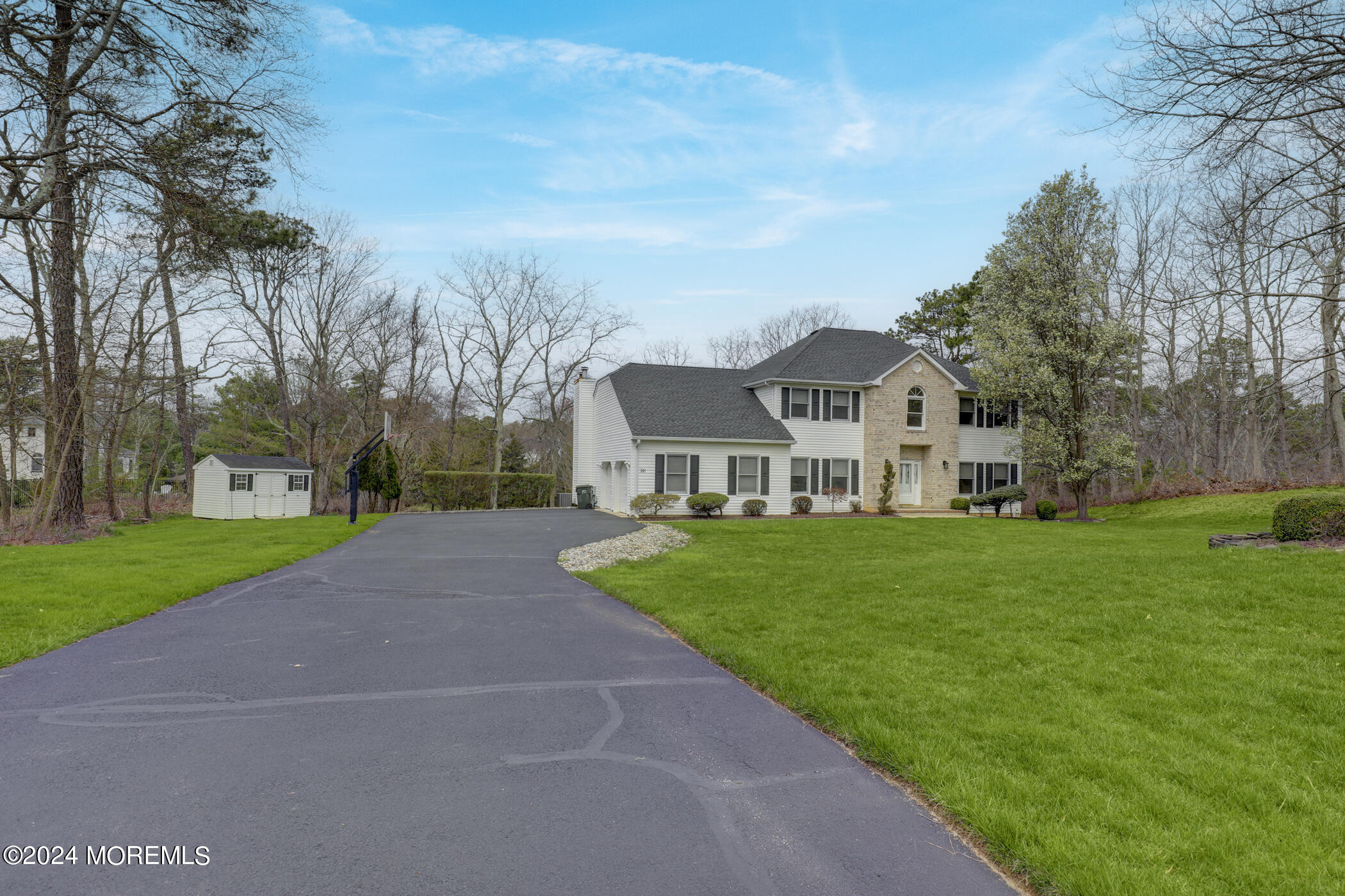 388 Jackson Mills Road Freehold, NJ 07728 - Photo 2 of 37 a view of a white house in front of a big yard with plants and large trees