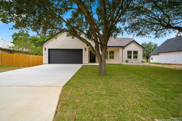 a front view of house with yard and trees