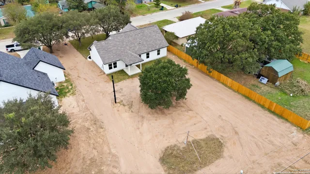 an aerial view of a house with a yard and lake view