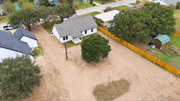 an aerial view of a house with a yard and lake view