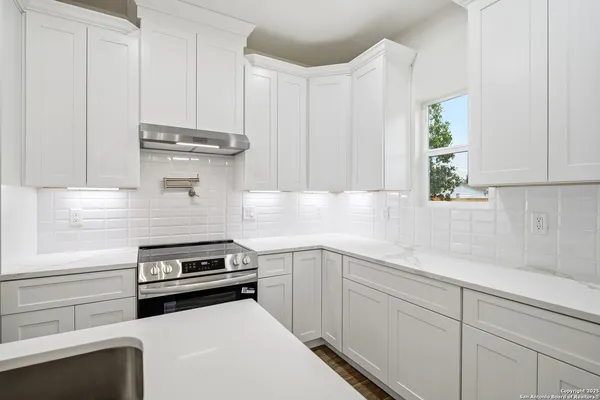 a kitchen with appliances a sink and cabinets