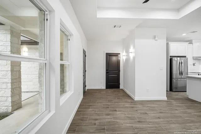 a view of a hallway with wooden floor and staircase
