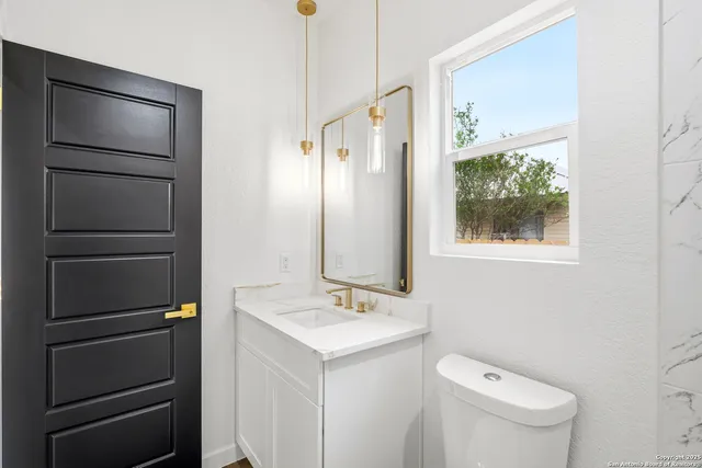 a bathroom with a toilet sink and mirror