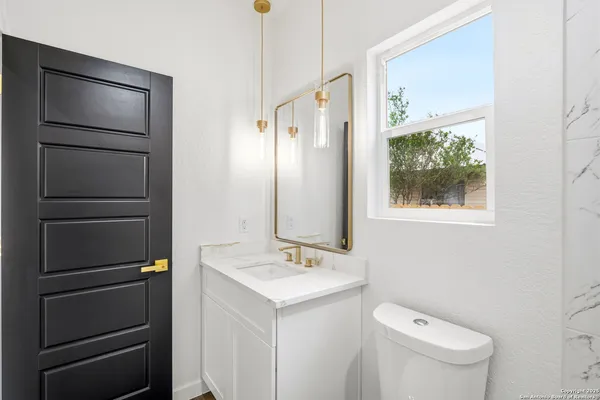 a bathroom with a toilet sink and mirror