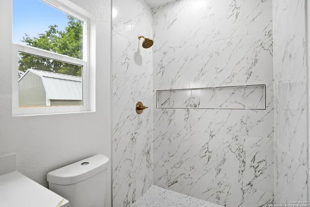 a bathroom with a toilet and a shower