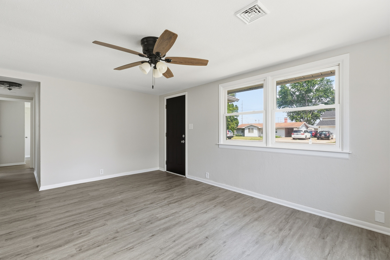 2306 9th Street Silvis, IL 61282 - Photo 9 of 32 a view of an empty room with wooden floor and a window