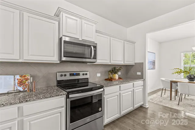 a living room with granite countertop kitchen island furniture and a chandelier