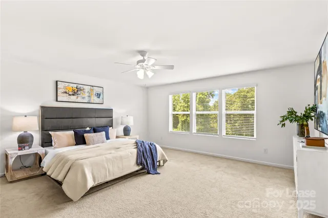a spacious bedroom with a bed and a chandelier