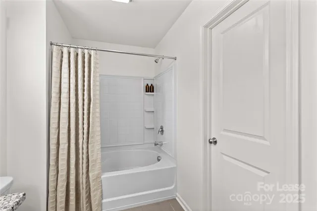 a bathroom with a granite countertop sink a toilet a mirror a bathtub and shower