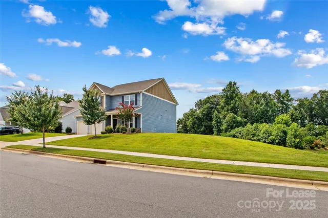 a view of a house with basketball court and palm trees