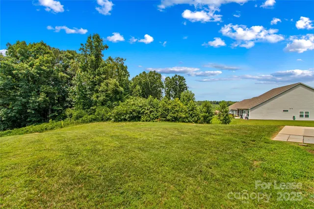 a view of a big yard with a house in the background
