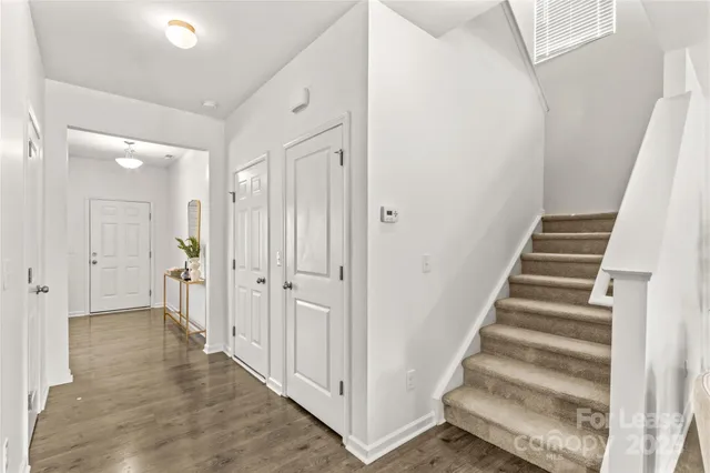 a view of a hallway with white walls and entryway