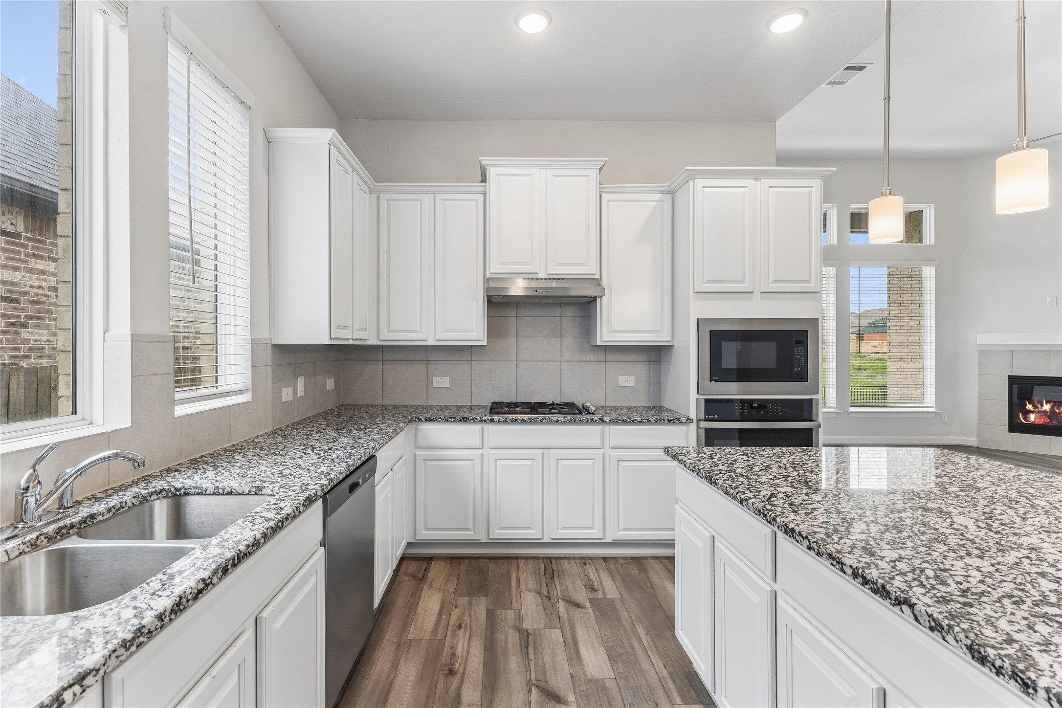 298 Wild Pecan Loop Buda, TX 78610 - Photo 10 of 40 a kitchen with stainless steel appliances granite countertop a sink stove and cabinets