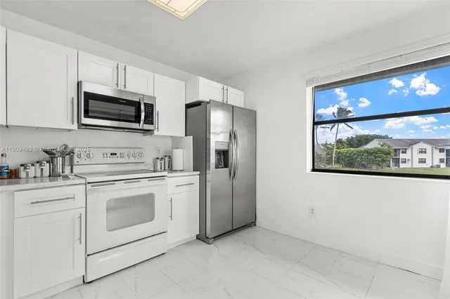 a kitchen with white cabinets and white appliances