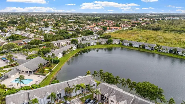 an aerial view of city and lake with trees