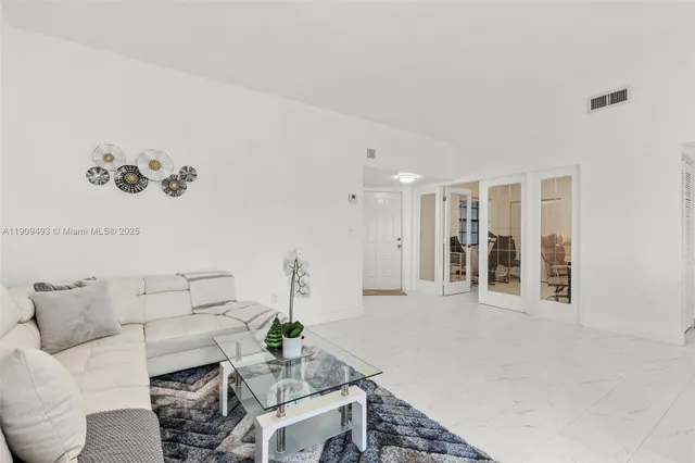 a living room with furniture and a floor to ceiling window