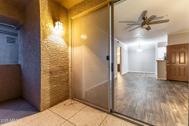 a view of a hallway with wooden floor and a kitchen