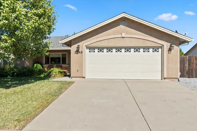 a view of a house with a yard and potted plants
