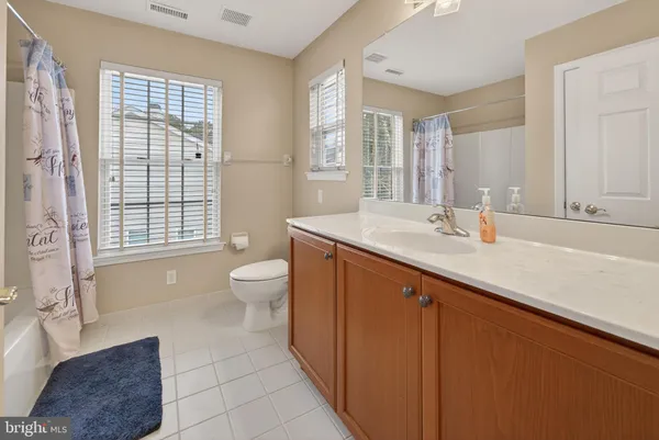 a spacious bathroom with a sink a toilet and a large mirror