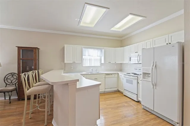 a kitchen with white cabinets and white appliances