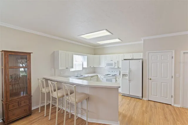 a kitchen with kitchen island granite countertop wooden floors and refrigerator