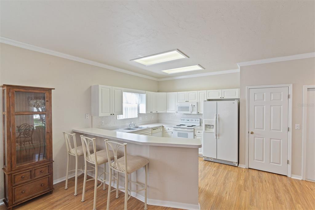 4748 Northwest 77 Road Gainesville, FL 32653 - Photo 5 of 21 a kitchen with kitchen island granite countertop wooden floors and refrigerator
